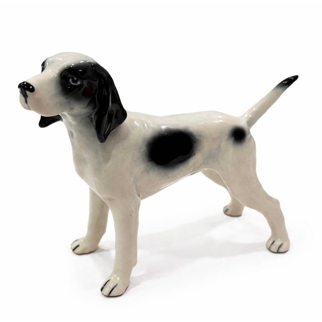 Vintage mid-century ceramic figurine depicting a classic hunting pointer dog in a standing alert pose. The piece features...