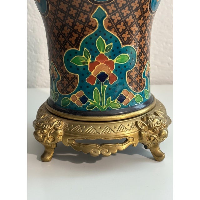 A richly decorative vintage Asian enamel vessel featuring a striking combination of turquoise, warm brown, green, rose and...