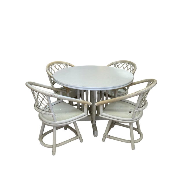 A charming and timeless Mid 20th Century dining set by Ficks Reed, crafted in painted cream rattan with elegant faux...