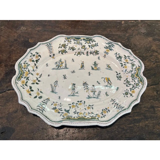 18th century polychrome French faience molded platter with scenes of gentry figures