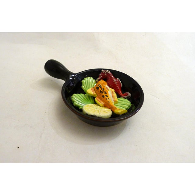 Small decorative wall-mounted pan/fondue with a trompe-l'oeil seaside design: black background & colorful "pinned"...