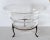 Circular flared glass bowl elevated on tripod metal stand with pad feet.