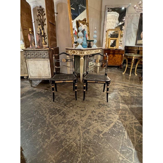 Good pair of vintage English Regency design black lacquered and gilded side chairs. Circa 1940. A timeless and classic...