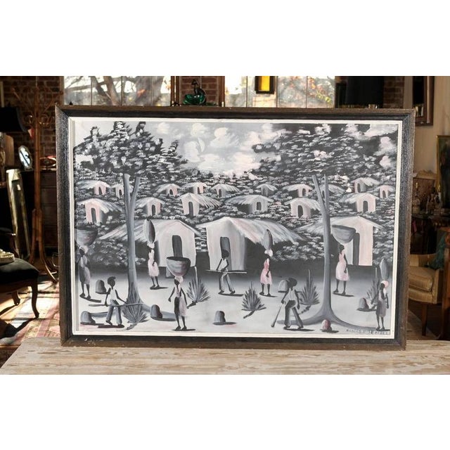 20th century Haitian oil on canvas of a village painted in hues of black, white, grey, and pale pink. Signed by the...