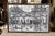 20th century Haitian oil on canvas of a village painted in hues of black, white, grey, and pale pink. Signed by the...