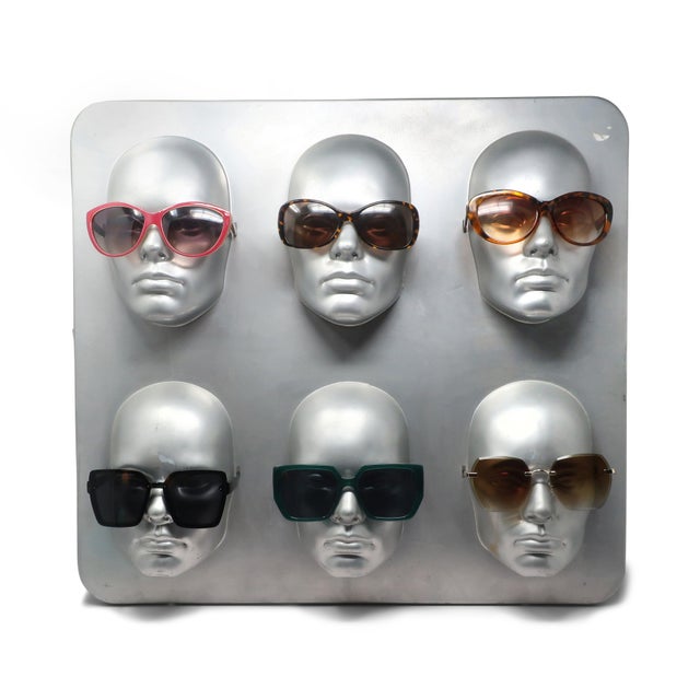 A stunning 1980s molded plastic eyeglass or sunglasses display. It has six three-dimensional heads with small slits near...