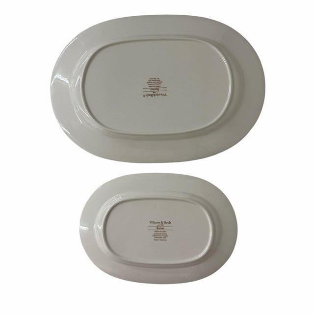 Offering a pair of Villeroy & Boch Basket platters. The pattern is a design of a green lattice band surrounding a basket...