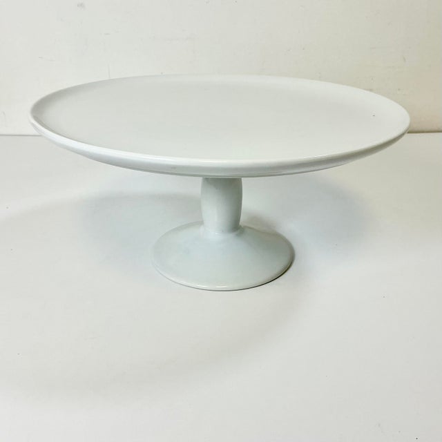 This large Cake Stand from Pottery Barn celebrates the beauty of minimalist service ware in a LeBlanca Porcelain. The...