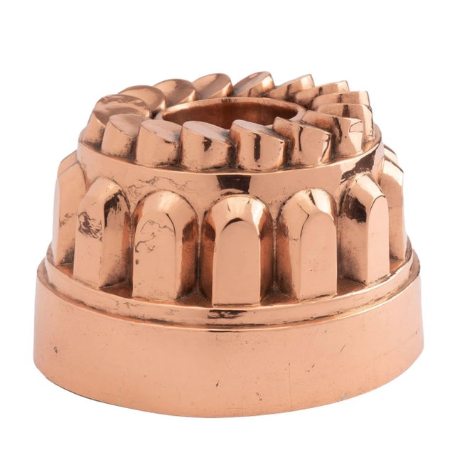 Copper “coin” bundt mold with tin lining. The mold features up-right buttress/turret elements above the deep rim which are...