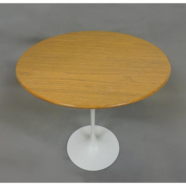 Classic tulip side table designed by Eero Saarinen and manufactured by Knoll. This table has a 20 inch diameter oak top, a...