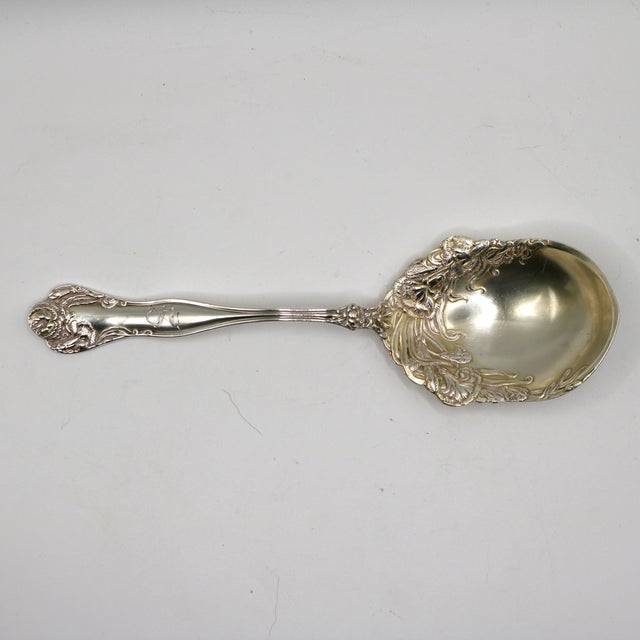 An exquisite turn-of-the-century sterling silver serving spoon in the highly coveted "Carnation" pattern by the Watson...