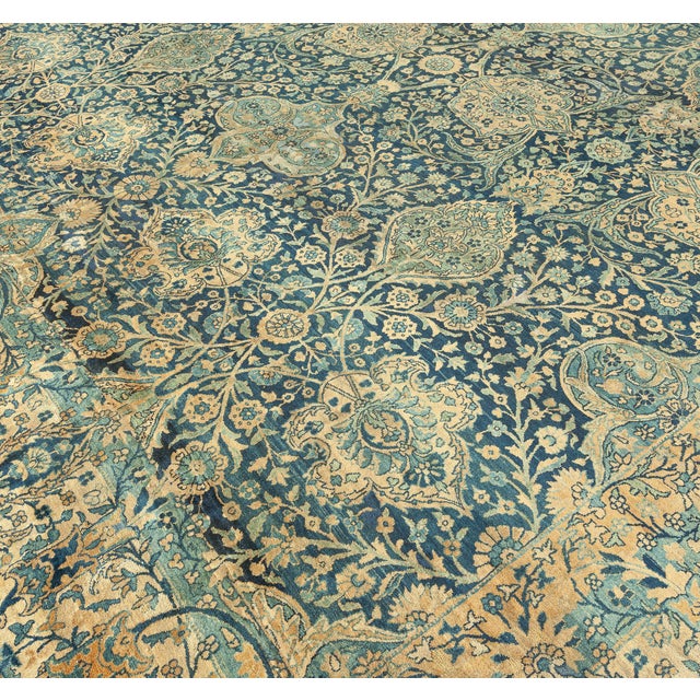 An early 20th century antique Southeast Persian Kirman rug, the midnight blue field with an enlarged palmette and floral...