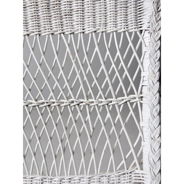 A vintage American white wicker chair from the 1930s–1940s, featuring a light, open frame and classic proportions. The...