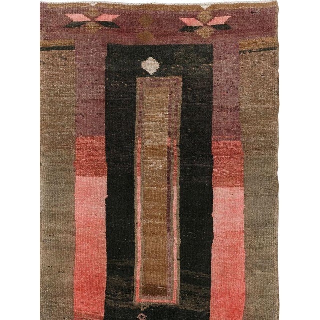 This mid-20th-century Turkish Anatolian runner presents a modern composition organized around a deep charcoal field...