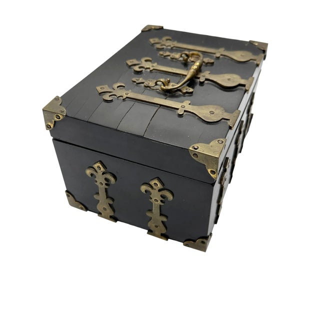 A large antique box from France. The wooden box has such a wonderful design with brass banding and a top handle. Has a...