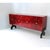 Sideboard with four doors, wooden structure covered with red parchment, base with black lacquered feet and golden handles....