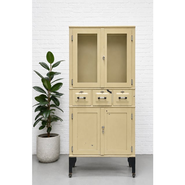 Metal Art Deco medical cabinet showcasing classic Industrial design, c. 1930’s. This substantial piece retains its...