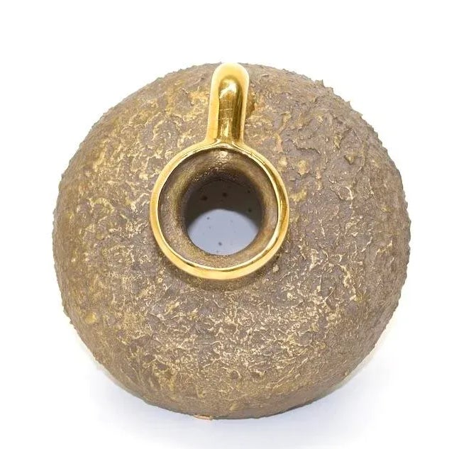 This large handcrafted tilted Amphora vessel or pitcher has a gold tone metal core with a textured finish. 1970s. The...