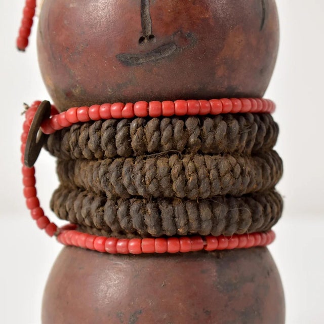 The Nyamwezi Beaded Fertility Doll Gourd with Shells from Tanzania is a stunning representation of fertility and...