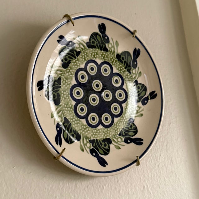 Small hand-painted Polish stoneware pottery plate made by Manufaktura in Bolesławiec. A cobalt peacock eye medallion is...