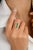 This modern antique ring features a captivating three-stone emerald axis design, elegantly set in 18k yellow gold. The...