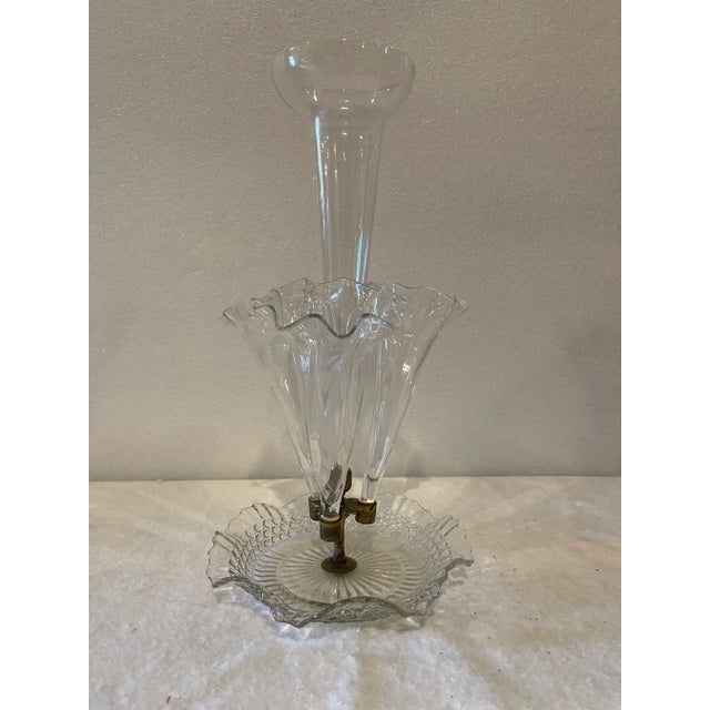 Antique clear blown glass epergne with a tall center trumpet vase with scalloped edges surrounded by three others. Base...