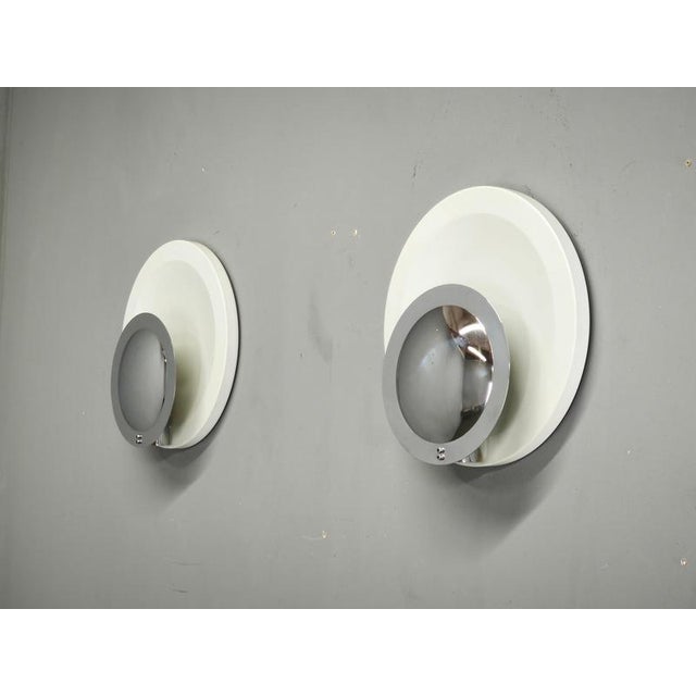 Sculptural pair of italian space age wall lights dating from the 1970s. The sconces feature a distinctive layered circular...