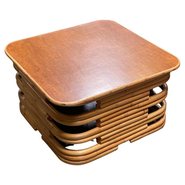 Mid-century coffee table features a striking, stacked rattan sculptural base constructed from multiple parallel tiers of...