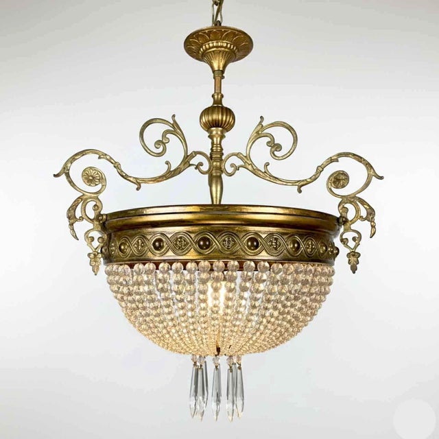 French brass and crystal hall chandelier made of a round brass band embossed with a sinuous Greek key containing ovals...