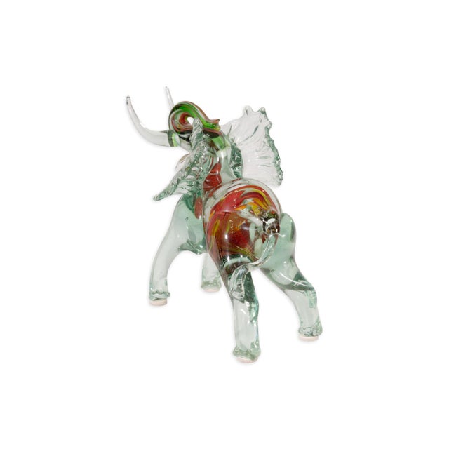 A hand-blown glass elephant sculpture from Murano, Italy, showcasing the region's celebrated artistry and technical...