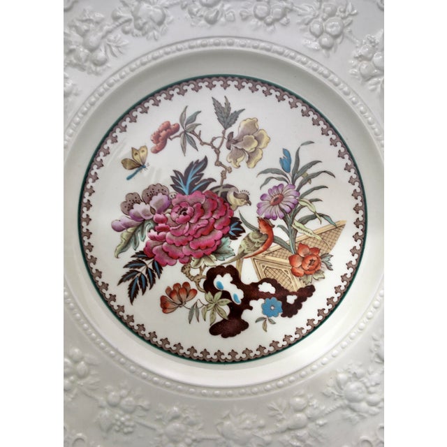 A classic Wedgwood raised border cream colored plate featuring a charming collection of flowers and birds in a rich...