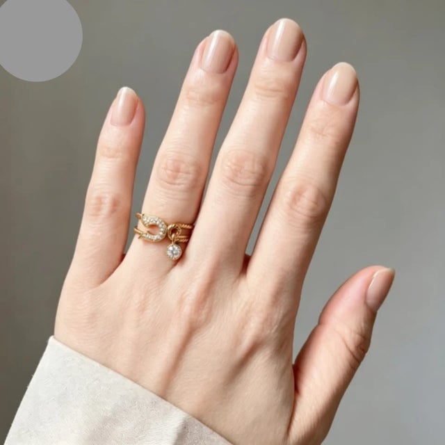 This 18K yellow gold safety pin charm band ring features numerous brilliant round diamonds, totaling 0.3 CT. The band is...