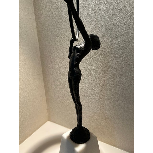 Elegant pair of contemporary abstract figural sculptures with candleholder tops, finished in matte black and mounted on...