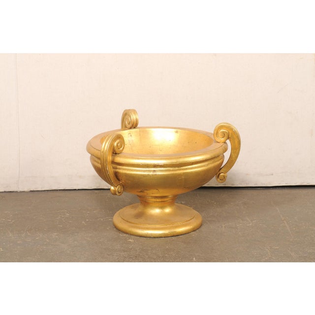 A striking Italian Neoclassical style giltwood urn from the 20th century. This vintage vessel from Italy, designed from...