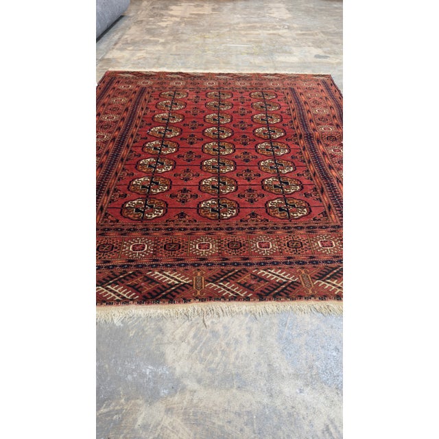 Beautiful vintage Persian Turkaman hand-knotted wool rug with a brown field. This piece has a beige frame and peach...