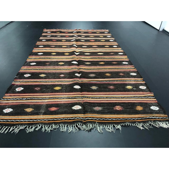 This is a vintage wool Turkish kilim rug. The piece was handmade in the 1960s.