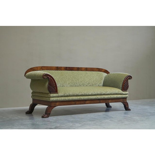 Sculptural Regency Sofa in Figured Mahogany Veneer and Velvet Early 19th Century A large and sculptural regency sofa in...