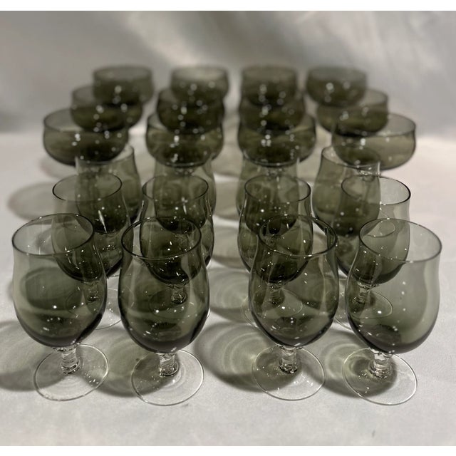 A large set of Mid-Century Modern Sasaki Japan crystal bar glasses in smoked crystal glass with clear twisted stems. The...