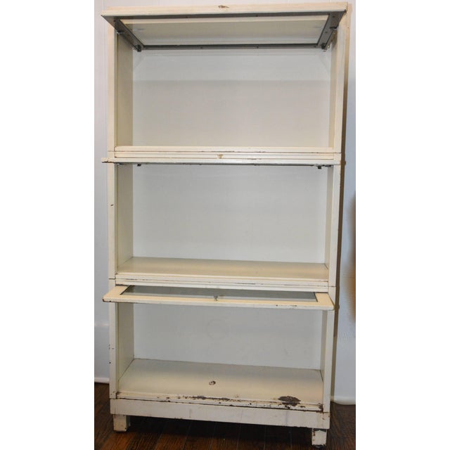 We are offering a Mid-Century Modern Barrister's bookcase for your collection! Three shelves with glass enclosed in metal...