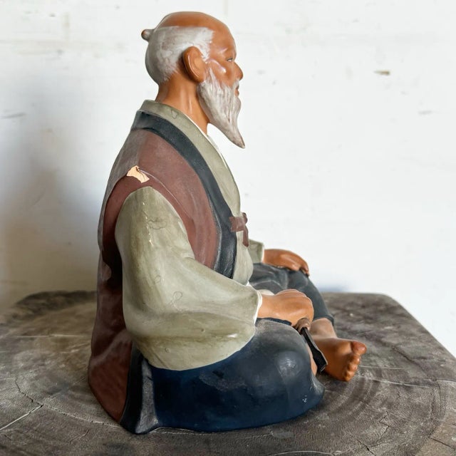 This vintage Hakata Mimasu clay doll portrays an elderly Japanese man seated in meditation, crafted with remarkable detail...