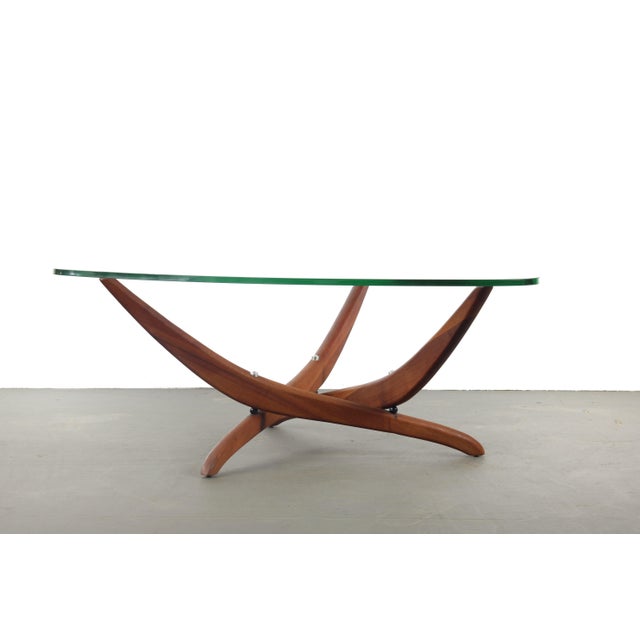 A boomerang glass top in pristine condition sits on a sculptural walnut base in this 1960s Forest Wilson table. Thick,...