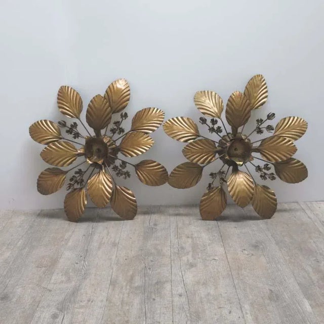 This pair of Hollywood Regency sconces was produced in France in the 1950s. They are made from bronzed metal in a floral...