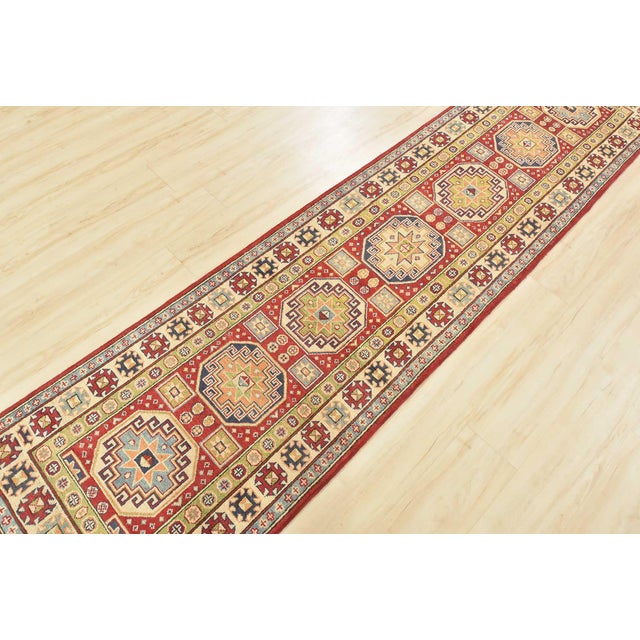 This traditional tribal geometric Caucasian Kazak runner is hand-knotted with an all-wool pile on a cotton foundation....