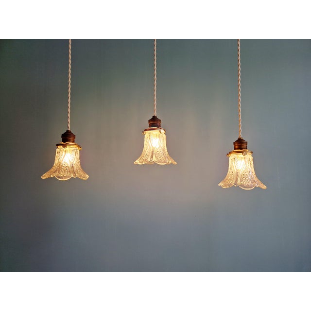Trio of Art Deco pendant/portable lamps in clear glass, 1920s-30s. Each lamp has been restored and is compatible with an...