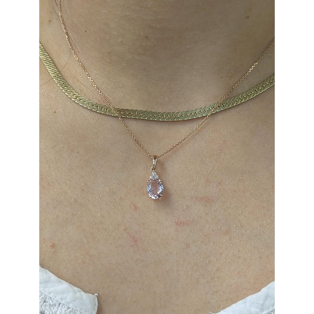 Sleek and sophisticated, this 14k solid gold pendant showcases a stunning oval 1-carat morganite with three subtle diamond...