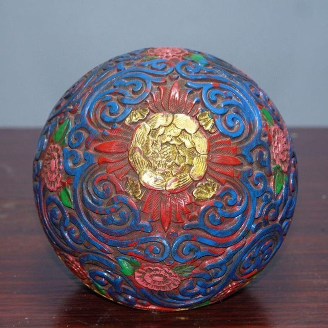 This beautiful vintage Chinese round lacquer lidded box features deeply carved relief work with swirling floral scroll...