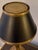 A Chapman & Myers library lamp for Visual Comfort with a warm brass finish, slender column, and black metal shade edged in...
