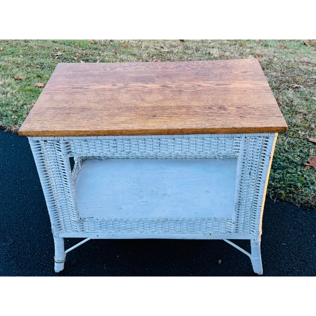 Vintage 1950s Oak Wood & White Wicker Rectangular Table. The table has a shelf for additional storage. The oak wood has a...