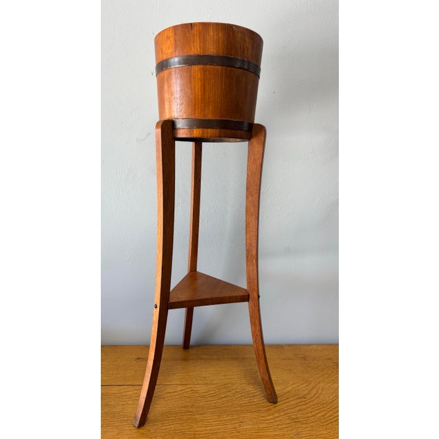 This early 20th century English oak coopered plant stand, crafted in the manner of R.H. Lister, is a quietly elegant...