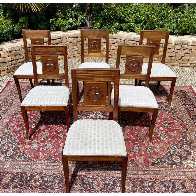 Suite of 6 Directoire style mahogany chairs. The seats are covered with a fabric. They are in good condition.